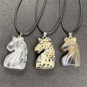 Macro detail of hand-carved tiger eye stone unicorn pendants on black woven ropes