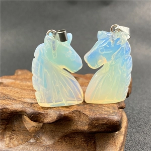 Detailed view of two unicorn opal pendants standing on a natural dark wood display stand