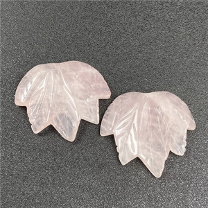 Detailed view of two rose quartz maple leaf pendants with fine carved leaf vein patterns