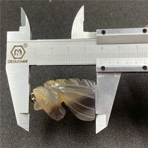 Tiger eye crystal unicorn pendant measuring approximately 34.2mm with a digital caliper