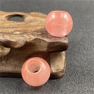 Macro view of two pink translucent 20mm big hole strawberry crystal beads on wood