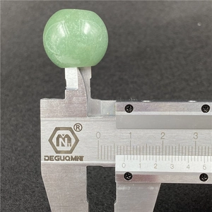 Caliper measuring a 20mm green aventurine agate bead with natural texture and polished surface