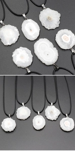 Macro view of natural white sunflower agate crystal pendant with silver clasp and cord