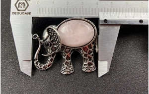 Détail d'un pendentif éléphant en cristal rose avec un cadre en argent vintage