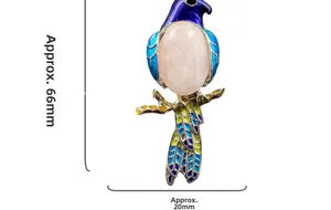 Detail view of colorful enamel magpie brooch with pink gemstone measuring 66mm by 20mm