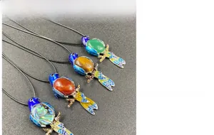 Macro view of bird pendants with colorful gemstones and vibrant enamel finish