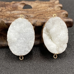 Macro detail of white druzy crystal pendant with gold electroplated edges for DIY jewelry