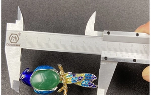Detailed measurement of colorful magpie brooch pendant with green gemstone inlay