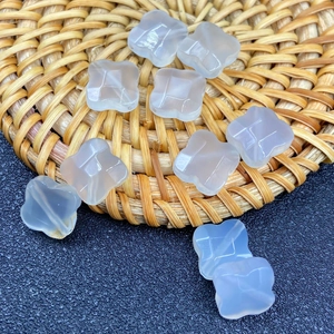 Macro detail of sky blue clover-shaped carved jade beads for DIY jewelry making