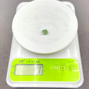 Detailed macro view showing the 1g weight of a carved green aventurine clover bead