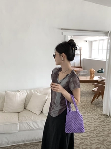 Détail d'un sac à main violet en maille ajourée fait main pour une tenue de vacances chic