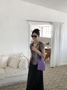 Gros plan sur un sac à main en paille crochetée violet avec une tenue d'été minimaliste