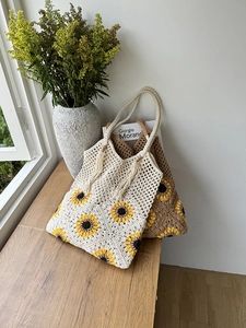 Detail of woven sunflower crochet tote bags in cream and brown with boho tassel accents