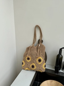 Detail of hand-woven cotton tote bag with yellow sunflower motif and fringe tassel
