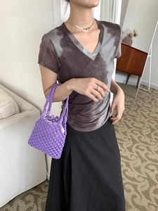 Détail du sac à main violet en crochet fait main avec texture ajourée sur une tenue chic