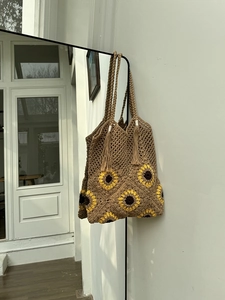 Close-up of woven tote bag with sunflower squares, hollow mesh and tassel details