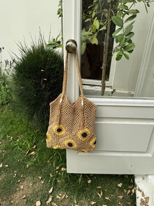 Detail of sunflower crochet tote bag showing woven texture, long fringe and wide strap