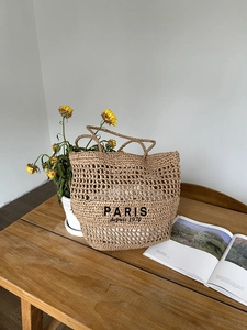 Detail der hohl gewebten Strohtasche mit Paris-Stickerei und weißem Innenfutter für den Urlaub