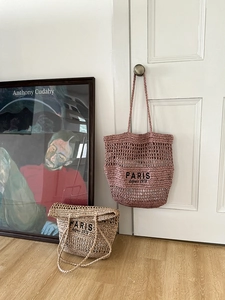 Detail von hohlgeflochtenen Strohtaschen mit Paris-Stickerei in Pink und Beige