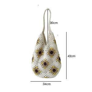 Detail of hand-woven shoulder bag showing white crochet texture and sunflower patterns