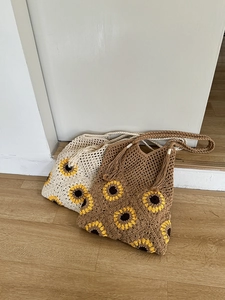 Detail of hand-woven crochet shoulder bags with sunflower patterns and tassel straps