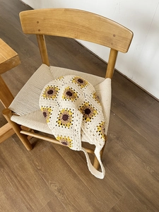 Detailed close-up of handmade crochet bag featuring yellow sunflower floral knit patterns