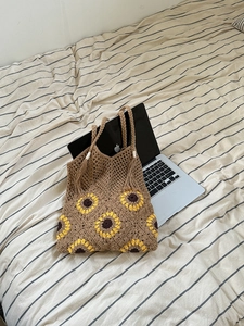 Detail of hand-woven tote bag featuring yellow sunflower patterns and tassel fringe edge