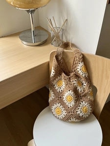 Detailed texture of handmade woven shoulder bag with large white daisy floral patterns