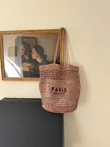 Detail der rosa Häkeltasche mit hohler Textur und Stickerei im Paris-Design