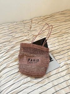 Detail der hohl gewebten Strohtasche in Altrosa mit PARIS depuis 1970 Bestickung