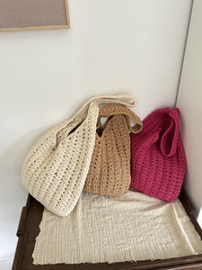 Close-up of hand-woven crochet beach bags in cream, khaki, and rose red colors
