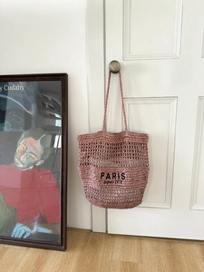 Detail der mauvefarbenen Häkeltasche mit schwarzer PARIS-Stickerei und offener Strickstruktur