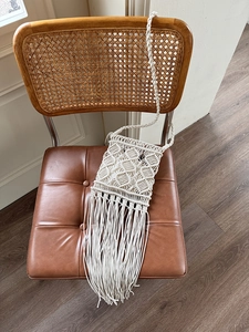 Detailed view of bohemian ivory hand-woven bag featuring long fringe and diamond mesh texture