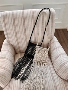 Detail of bohemian handmade woven bags with long tassels in black and beige colors