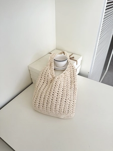 Detailed close-up of beige crochet woven tote bag with hollow geometric patterns