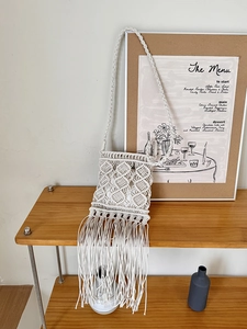 Close-up of bohemian macrame crossbody bag with hand-woven tassel details and diamond pattern