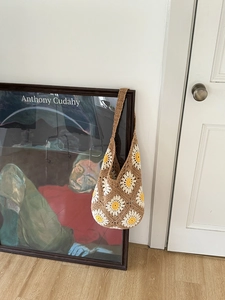 Detail of hand-woven crochet shoulder bag with white and yellow daisy flower patterns