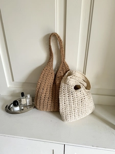 Detail of hand-woven crochet bags in beige and brown with hollow wave patterns