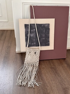 Detail of bohemian hand-woven cream cotton bag featuring intricate geometric fringe design