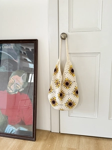 Detail of hand-woven sunflower crochet tote bag in creamy white cotton with wide strap