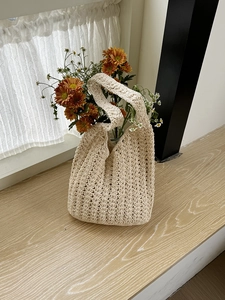 Detailed close-up of beige crochet tote bag texture with natural boho style and flowers