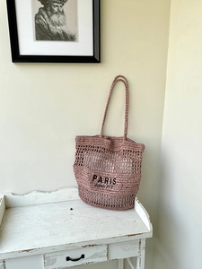 Detail der rosa geflochtenen Strohtasche mit Paris-Stickerei und Häkeldesign