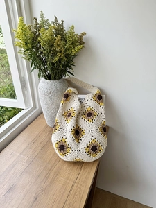 Macro detail of hand-woven sunflower crochet bag showing cotton stitch texture and patterns
