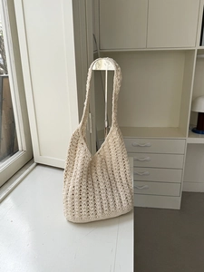 Detailed close-up of handmade crochet texture on an off-white woven shoulder bag