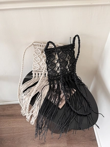 Detailed macro view of bohemian macrame crossbody bags with long fringe tassels in cream and black