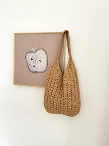 Close-up of bohemian woven shoulder bag with intricate hollow-out leaf crochet pattern