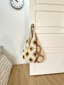 Detail view of handmade crochet tote bags with sunflower and daisy floral patterns
