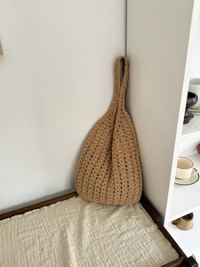 Detail of the dense crochet texture on this khaki woven shoulder bag for beach trips