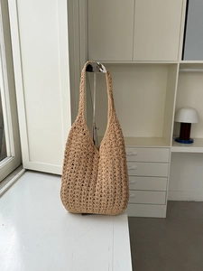Detail of hand-woven crochet shoulder bag featuring khaki hollow-out patterns and long strap