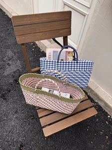 Close-up of handwoven plastic storage baskets in plaid and color-block patterns